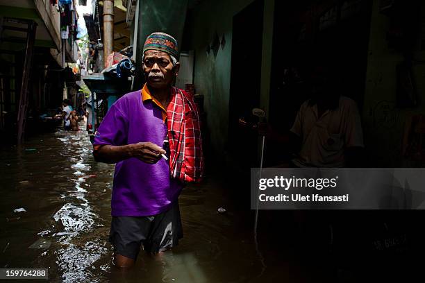 Man makes his way through floodwaters as major floods hit North Jakarta on January 20, 2013 in Jakarta, Indonesia. The death toll has risen to at...