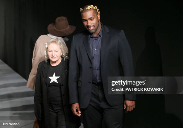 French judo champion Teddy Riner and French designer Agnes B salute the crowd on January 20, 2013 after the presentation of her men's fall-winter...