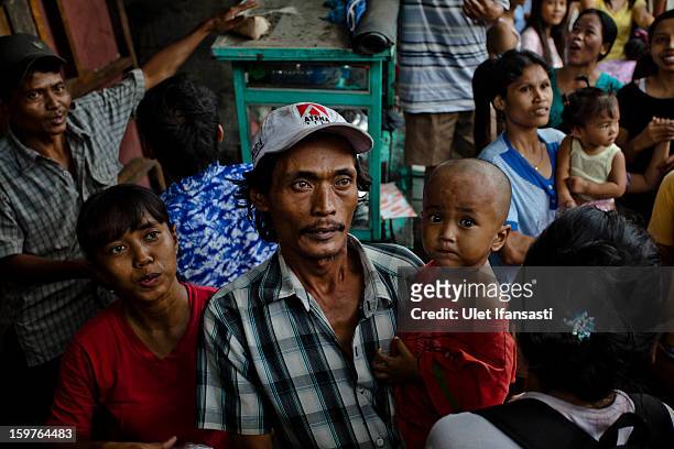 People queue for food aid as major floods hit North Jakarta on January 20, 2013 in Jakarta, Indonesia. The death toll has risen to at least 21 since...