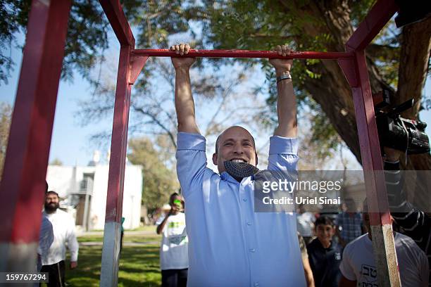 Naftali Bennett , head of HaBayit HaYehudi Party, the Jewish Home party, does chin-ups after talking to students at a pre-army training school as he...