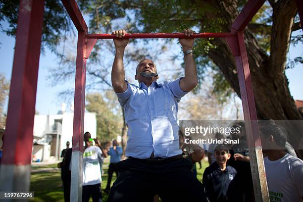 Naftali Bennett , head of HaBayit HaYehudi Party, the Jewish Home party, does chin-ups after talking to students at a pre-army training school as he...