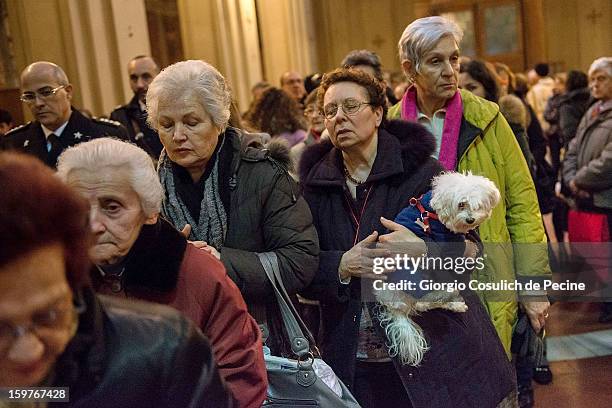 Woman waits to receive communion as she holds her dog during a traditional mass for the blessing of animals at the Sant'Eusebio church on January 20,...