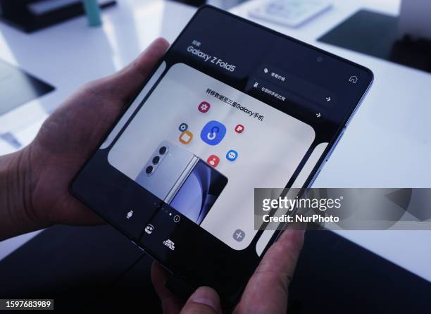 Customers experience Samsung's new flagship fold-screen phone Galaxy Z Fold5 at a Samsung sales store in Hangzhou, East China's Zhejiang province,...