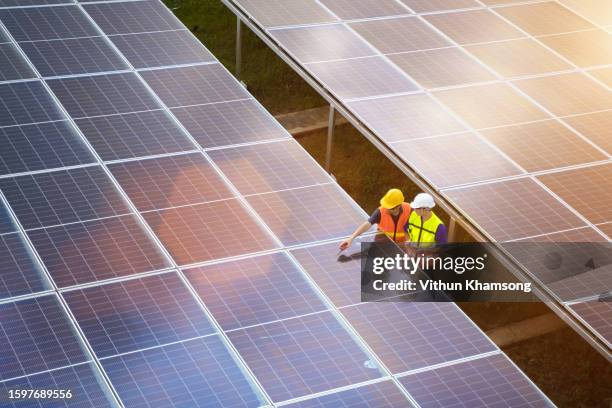 aerial view solar energy team working at solar power station - nachhaltige energie stock-fotos und bilder
