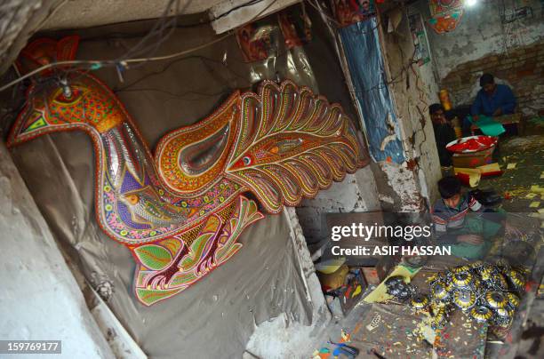 Pakistani artisans work on making decorations for truck and cars, in Rawalpindi, on January 20, 2013. Many trucks, buses and vans in Pakistan are...