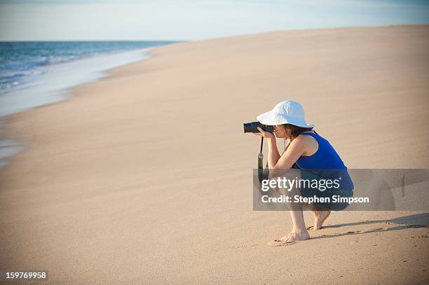 woman photographing on pristine empty beach - playa la cachora stock pictures, royalty-free photos & images