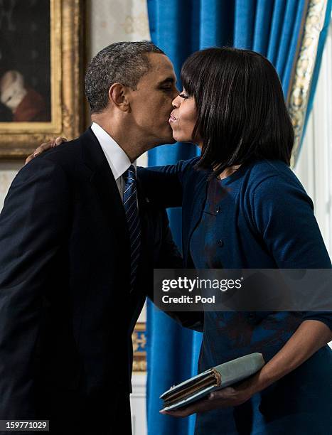 President Barack Obama kisses first lady Michelle Obama after being officially sworn-in in the Blue Room of the White House during the 57th...