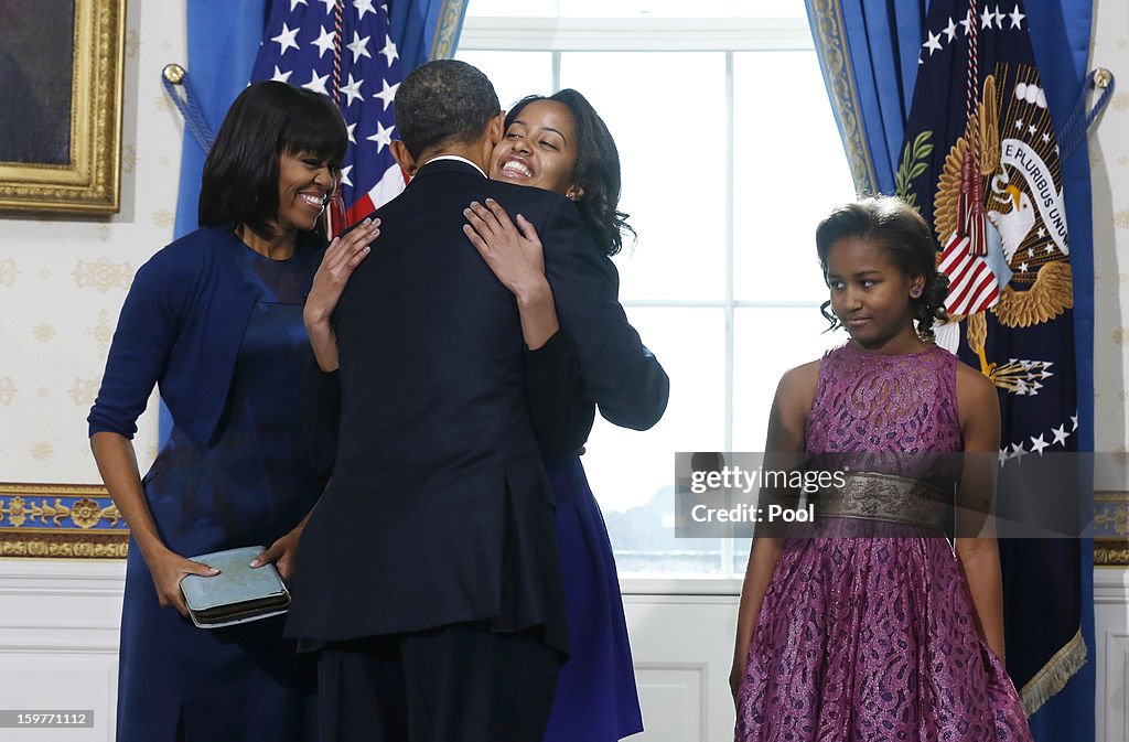 U.S President Barack Obama (L) takes the oath of office as first lady Michelle Obama holds the bible in the Blue Room of the White House in Washington