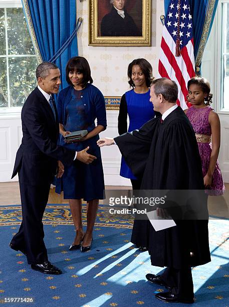 President Barack Obama shakes hands U.S. Supreme Court Chief Justice John Roberts after takes the oath of office as first lady Michelle Obama ,...