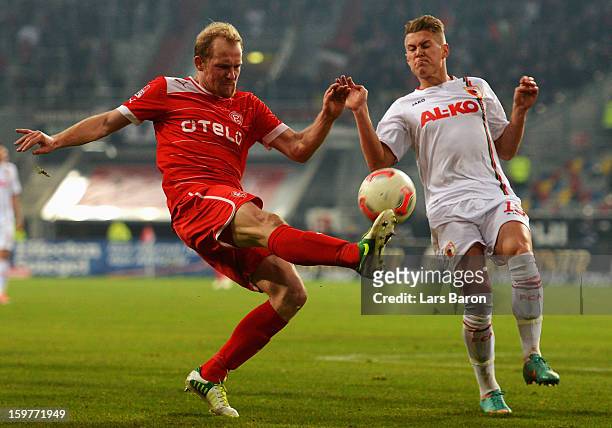 Tobias Levels of Duesseldorf is challenged by Ronny Philip of Augsburg during the Bundesliga match between Fortuna Duesseldorf 1895 and FC Augsburg...