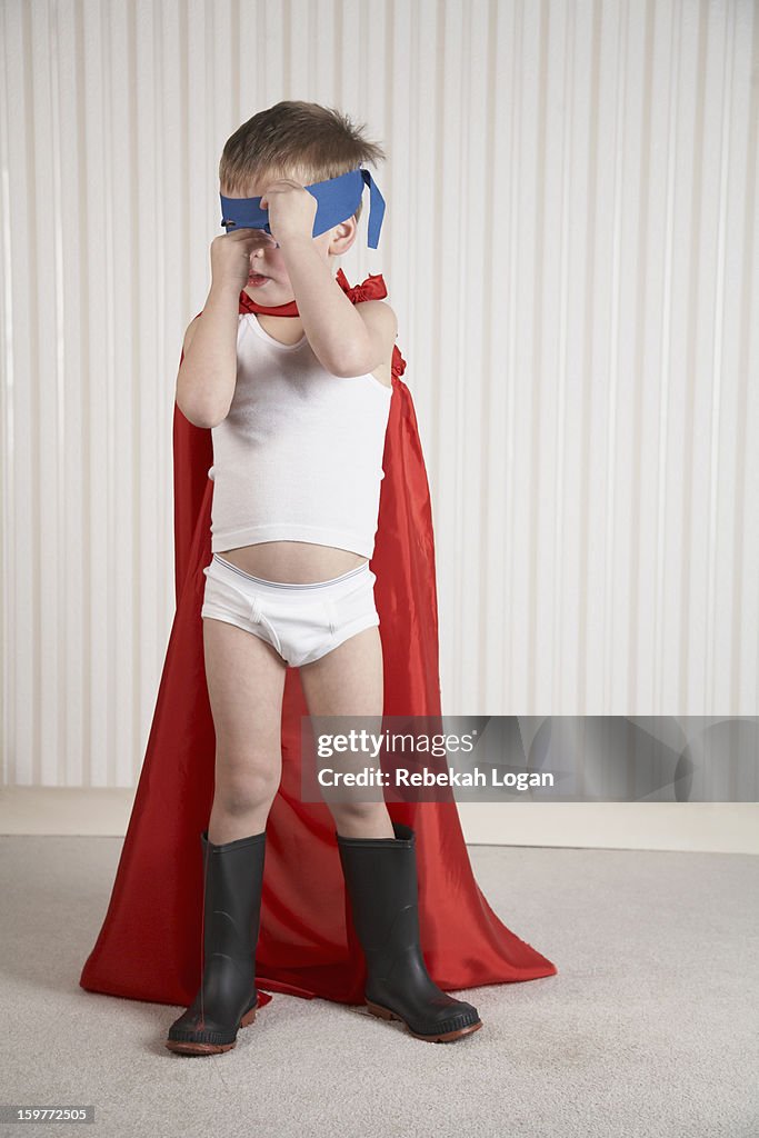 Small boy dressed as superhero.