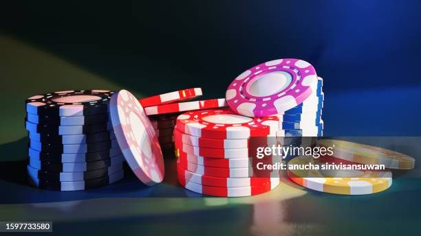 several stacked casino tokens on a light blue and dark green background. - ficha de apuestas fotografías e imágenes de stock