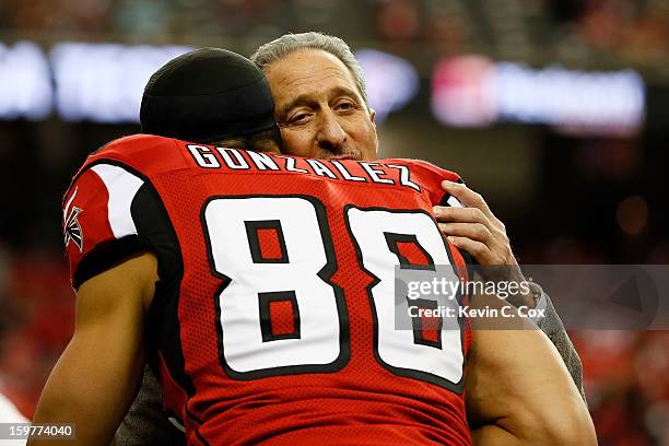 Owner Arthur Blank of the Atlanta Falcons hugs tight end tight end Tony Gonzalez before the Falcons take on the San Francisco 49ers in the NFC...