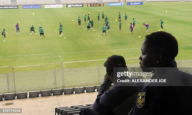 South African police agents watch players of the Togo's football national team taking part in a training session on January 20, 2013 at Moruleng...