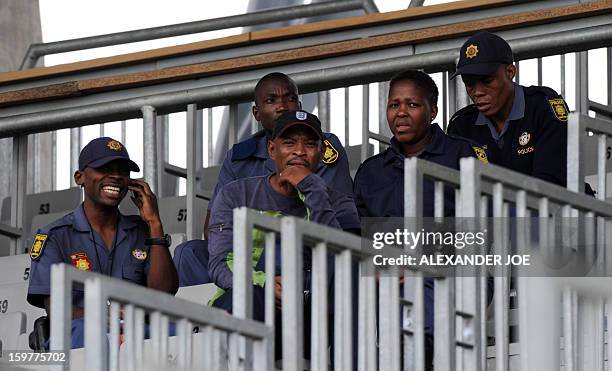 South African police officers stand guard as Togo team players take part in a training session in Moruleng on January 20 at the Moruleng Stadium....