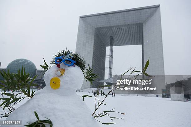 Snowman is seen in the front of La Grande Arche as snow covers the ground of La Defense on January 19 in Paris, France. Heavy snowfall fell...