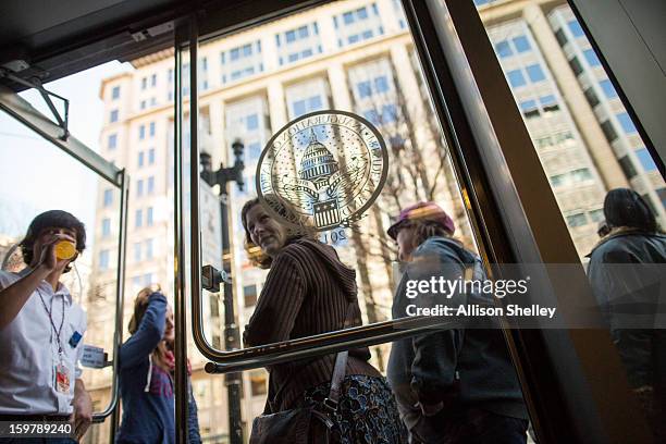 People wait ina line that snakes down the street at the entrance to the official inauguration merchandise store January 20, 2013 in Washington D.C....