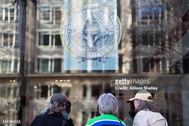 Visitors look through the window of the official inauguration merchandise store January 20, 2013 in Washington D.C. Despite this crowd, souvenir...
