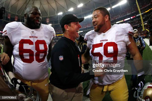 Leonard Davis and head coach Jim Harbaugh and Jonathan Goodwin of the San Francisco 49ers celebrate as they walk off of the field after they won...