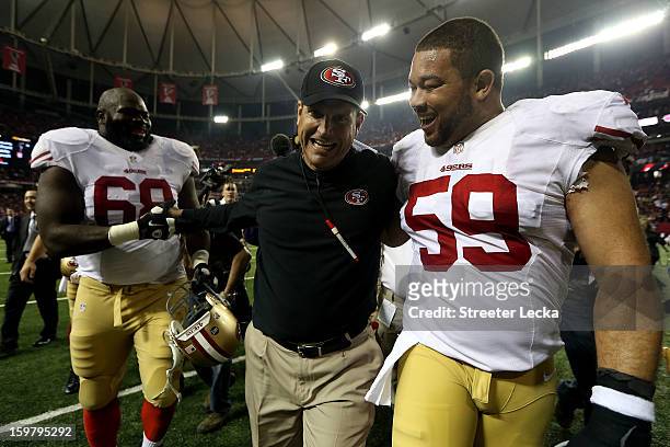 Leonard Davis and head coach Jim Harbaugh and Jonathan Goodwin of the San Francisco 49ers celebrate as they walk off of the field after they won...