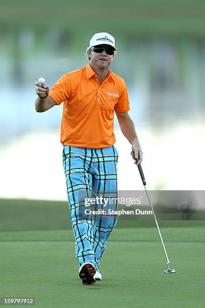 Brian Gay holds up his ball after sinking a birdie putt on the second playoff hole to win the tournament during the final round of the Humana...