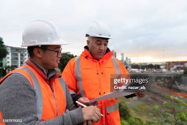 engineer and architect looking at blueprint on construction site. - housing development plans stock pictures, royalty-free photos & images