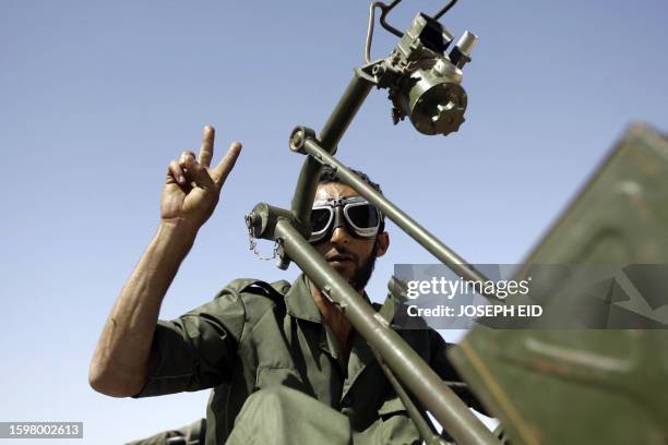 Libyan National Transitional Council flashes the V for "victory" sign as he arrives at the frontline on the outskirts of the city of Bani Walid, one...