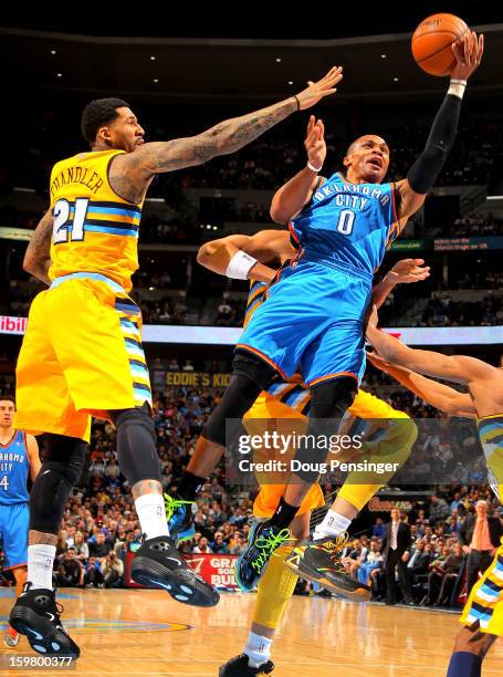 Russell Westbrook of the Oklahoma City Thunder lays up a shot against Wilson Chandler of the Denver Nuggets at the Pepsi Center on January 20, 2013...