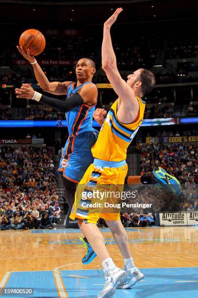 Russell Westbrook of the Oklahoma City Thunder is fouled by Kosta Koufos of the Denver Nuggets as he takes a shot at the Pepsi Center on January 20,...