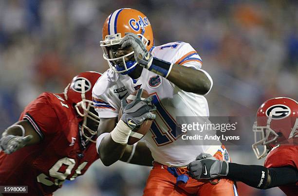 Small of the University of Florida runs past two University of Georgia defenders during the game at Alltel Stadium on November 2, 2002 in...