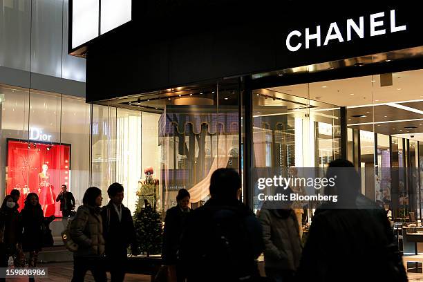 Pedestrians walk past a Chanel SA store, right, and a Christian Dior SA store in the Omotesando district of Tokyo, Japan, on Saturday, Jan. 19, 2013....