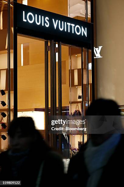 Pedestrians walk past a Louis Vuitton store, operated by LVMH Moet Hennessy Louis Vuitton SA, in the Omotesando district of Tokyo, Japan, on...