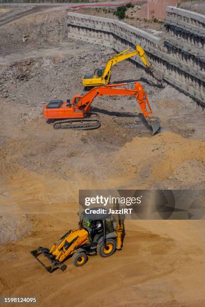 máquinas excavando en el sitio de construcción - mina de superficie fotografías e imágenes de stock