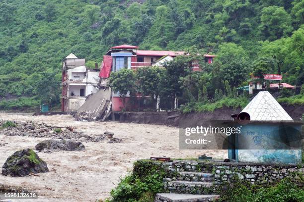 Portion of college building is seen collapsed along the river Maldevta after heavy rains in Dehradun on August 14, 2023. At least 24 people have been...