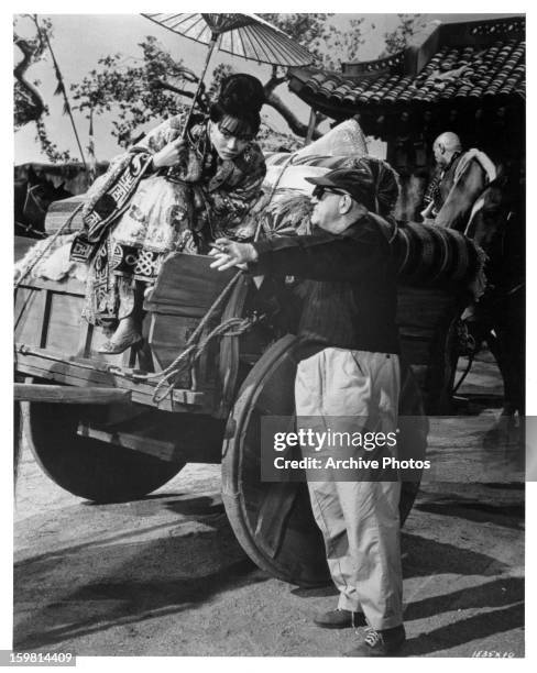 John Ford, director giving instructions to Jane Chang from the film 'Seven Women', 1966.