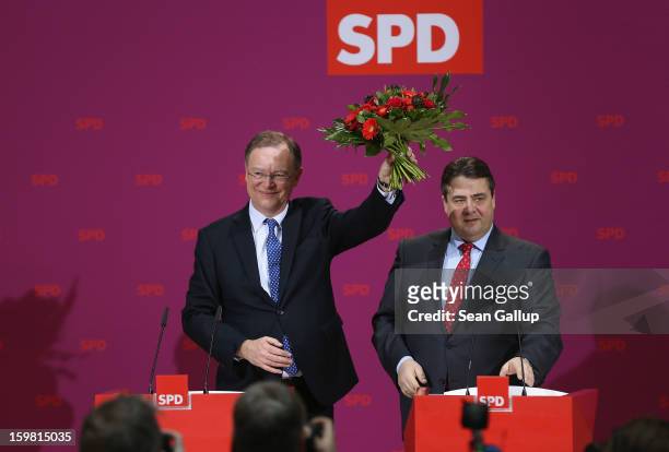 Stephan Weil, gubernatorial candidate in Lower Saxony for the German Social Democrats , holds up flowers he received from SPD Chairman Sigmar Gabriel...