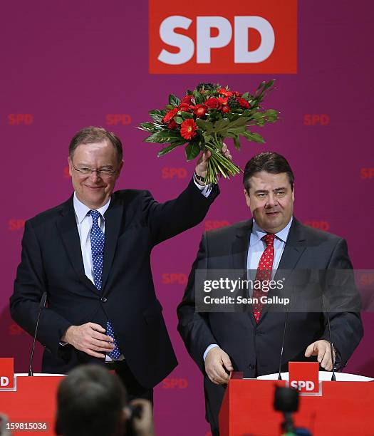 Stephan Weil, gubernatorial candidate in Lower Saxony for the German Social Democrats , holds up flowers he received from SPD Chairman Sigmar Gabriel...