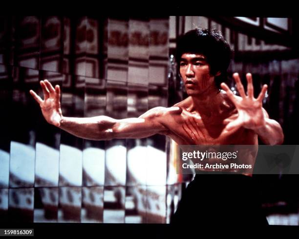 Bruce Lee with fresh scratch marks on his face and chest in a scene from the film 'Enter The Dragon', 1973.