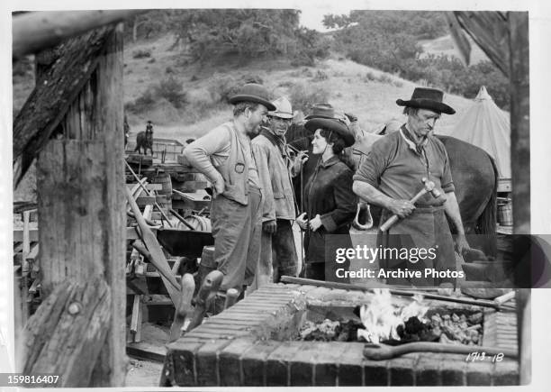 Susan Cabot talking with a man in a scene from the film 'Gunsmoke', 1953.
