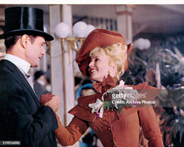 Louis Jourdan grabbing the hand of Leslie Caron in a scene from the film 'Gigi', 1958.