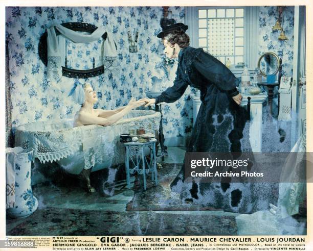 Isabel Jeans reaches out to Hermione Gingold from the bathtub in a scene from the film 'Gigi', 1958.