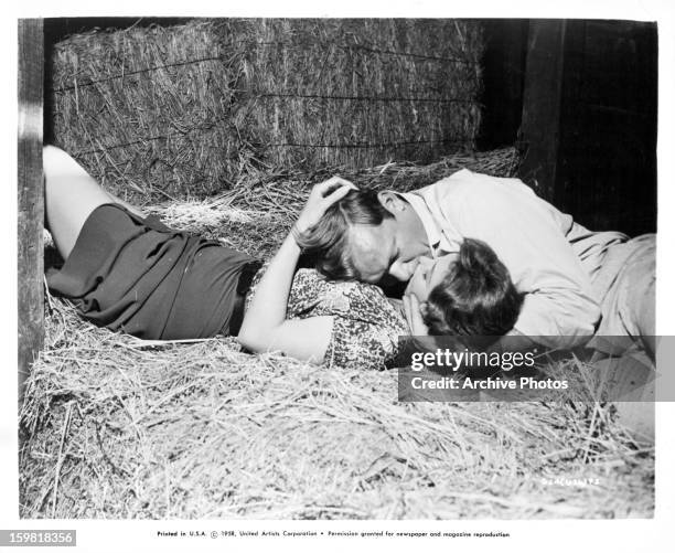 Tina Louise and Aldo Ray kissing in the hay in a scene from the film 'God's Little Acre', 1958.