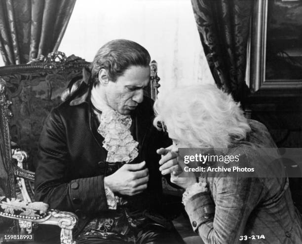 Murray Abraham reacts as Tom Hulce kisses his hand in a scene from the film 'Amadeus', 1984.