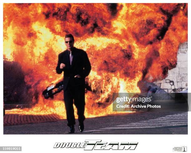 Jean-Claude Van Damme walks away from an explosion in a scene from the film 'Double Team', 1997.