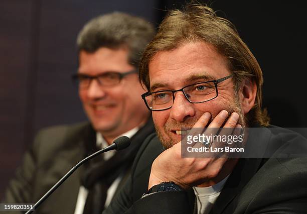 Juergen Klopp, head coach of Borussia Dortmund, smiles next to Herbert Fandel, head of the DFB referee commission, during a press conference after...