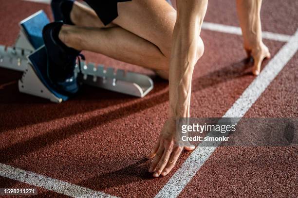 corredor masculino al inicio de la carrera - atletismo en pista masculino fotografías e imágenes de stock