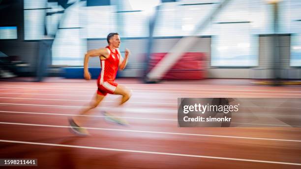 athlet mann, der auf der strecke läuft - sprint-sport-wettbewerbsform stock-fotos und bilder