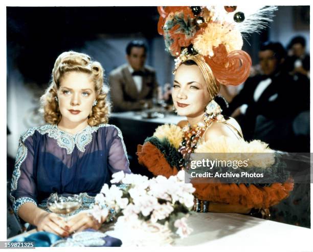 Alice Faye sitting at table with Carmen Miranda in a scene from the film 'Week-End In Havana', 1941.