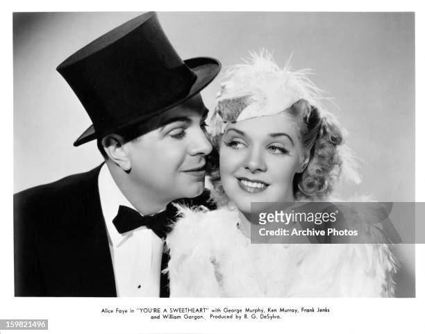Ken Murray cozying up to Alice Faye in publicity portrait for the film 'You're A Sweetheart', 1937.