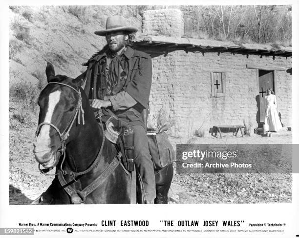 Clint Eastwood, as Josey Wales, riding off on horseback, as Laura Lee looks on, in a scene from Eastwood's 1976 western, 'The Outlaw Josey Wales'.